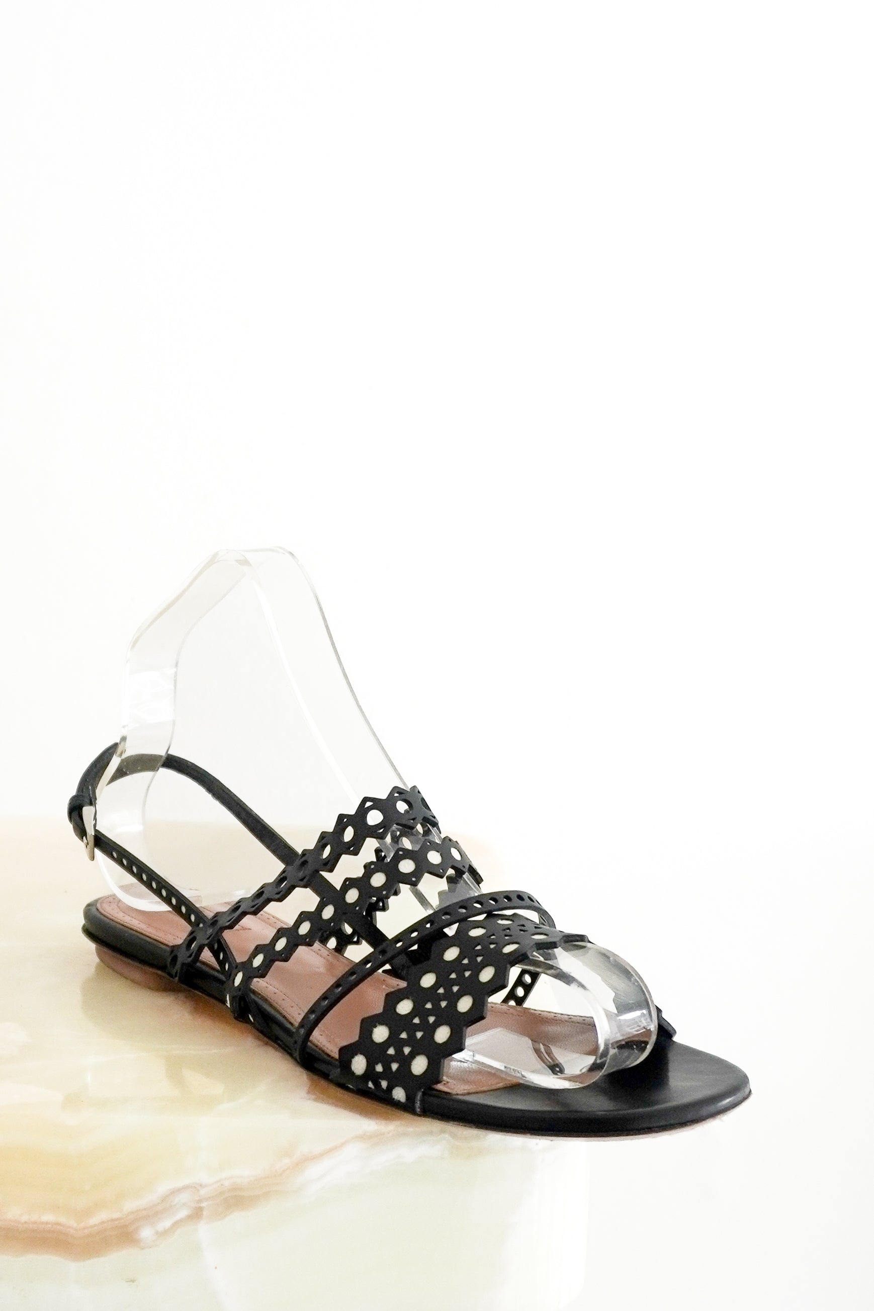 ALAÏA Laser-Cut Leather Flat Sandals in Black main photo chelsea london