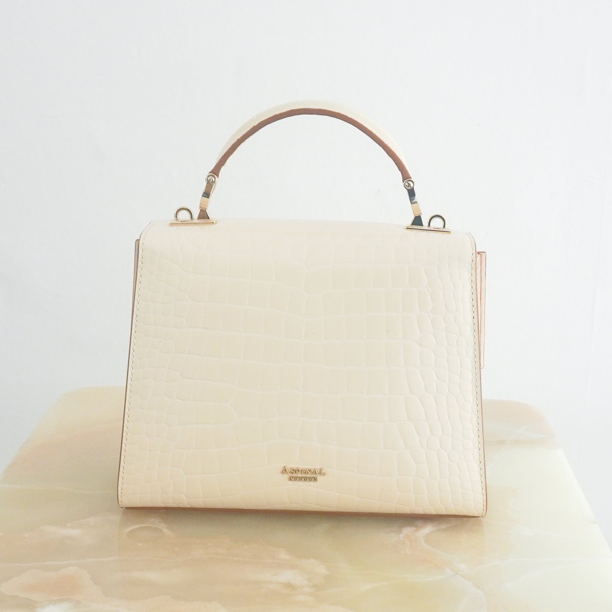 Back photo of Aspinal of London Mayfair crossbody bag in white croc-effect leather with a top handle and signature shield lock hardware.