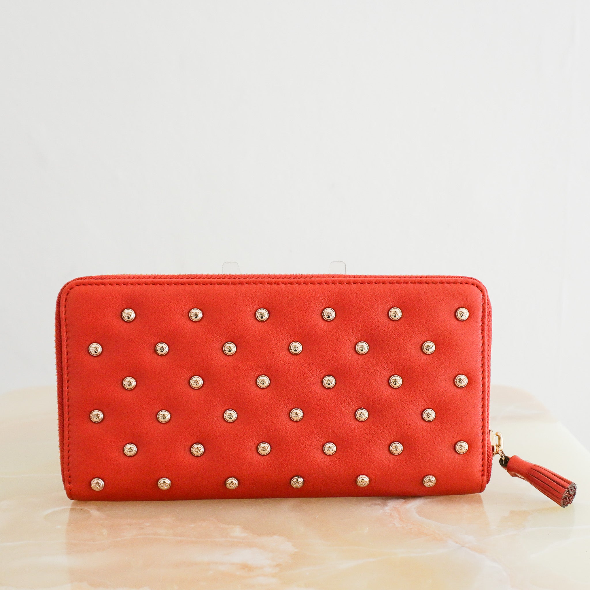 Back image of the Anya Hindmarch Studded Leather Zip Around Wallet in Orange