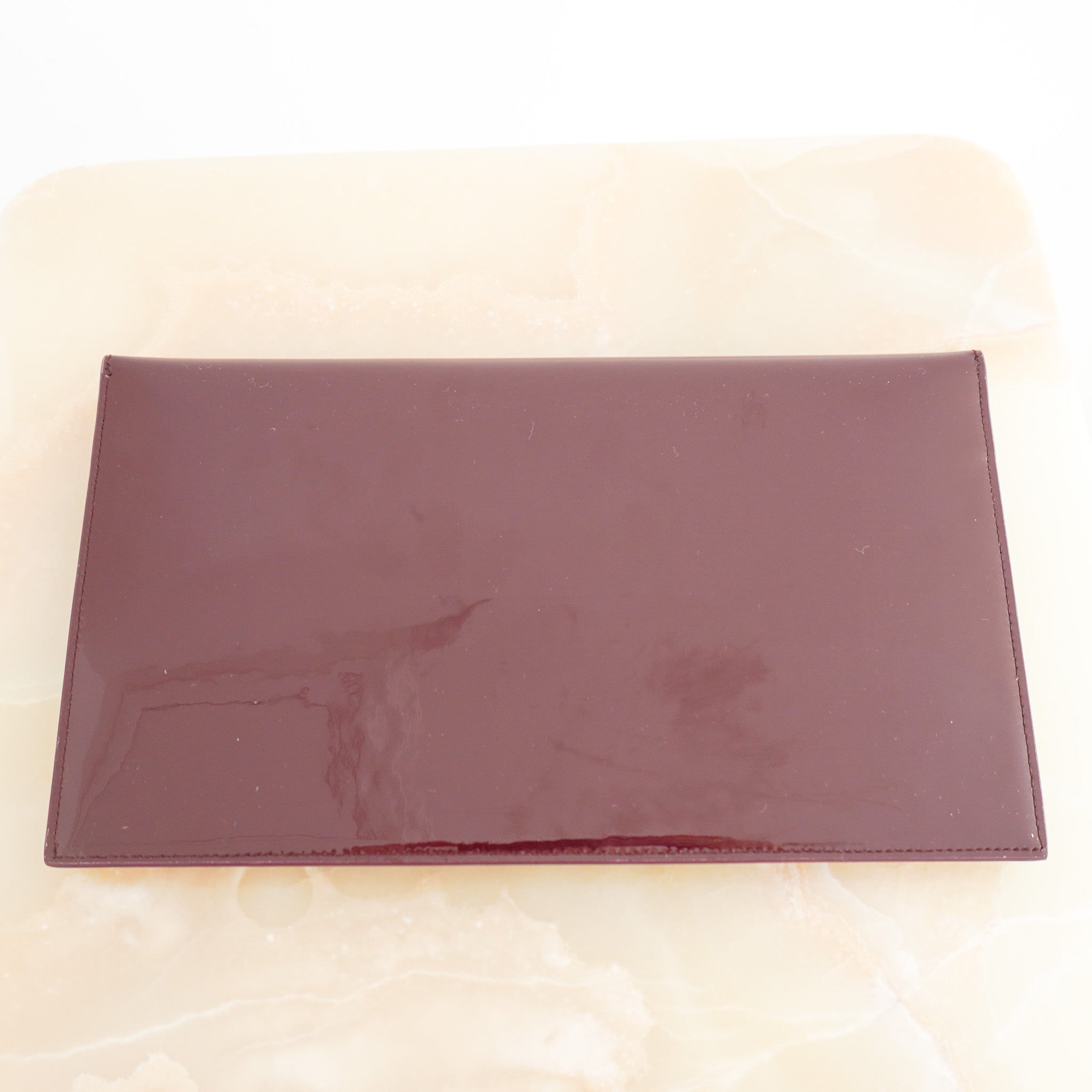 Back image of the Saint Laurent Uptown Pouch in Dark Red Patent Leather