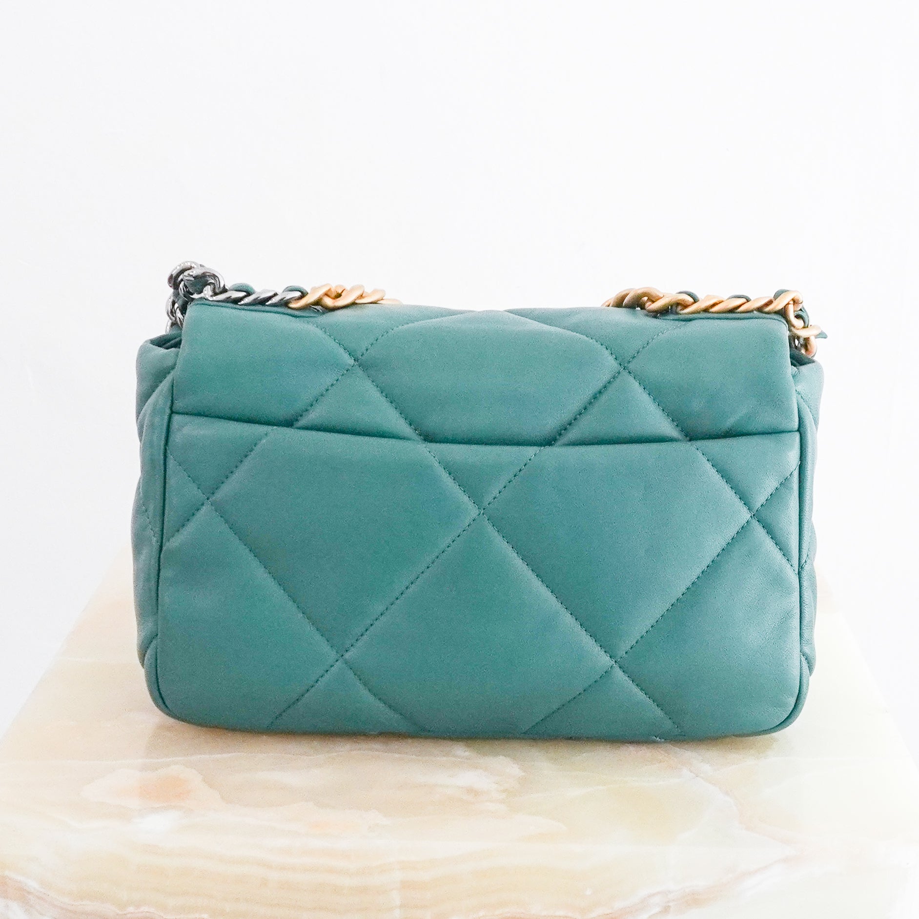 Back photo of a Chanel 19 Small Flap Bag crafted from supple aged calfskin leather with the collection's signature oversized diamond quilting.