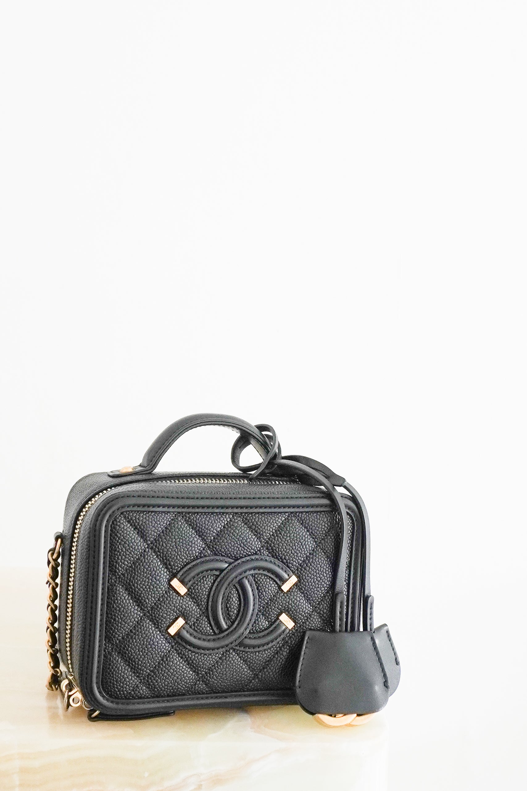 Front photo of a Chanel Vanity Case Crossbody Bag, crafted from luxurious black quilted caviar leather and finished with elegant champagne gold-tone hardware.