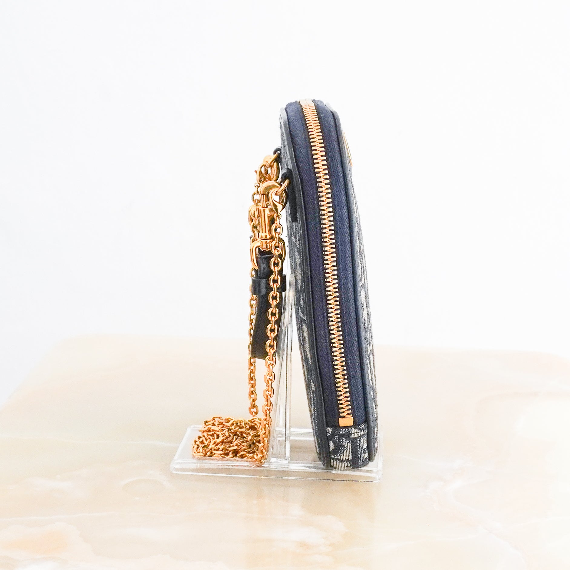 Side photo of a Dior 30 Montaigne Tech Holder is crafted from the House's iconic blue Dior Oblique jacquard canvas and finished with elegant gold-tone hardware.