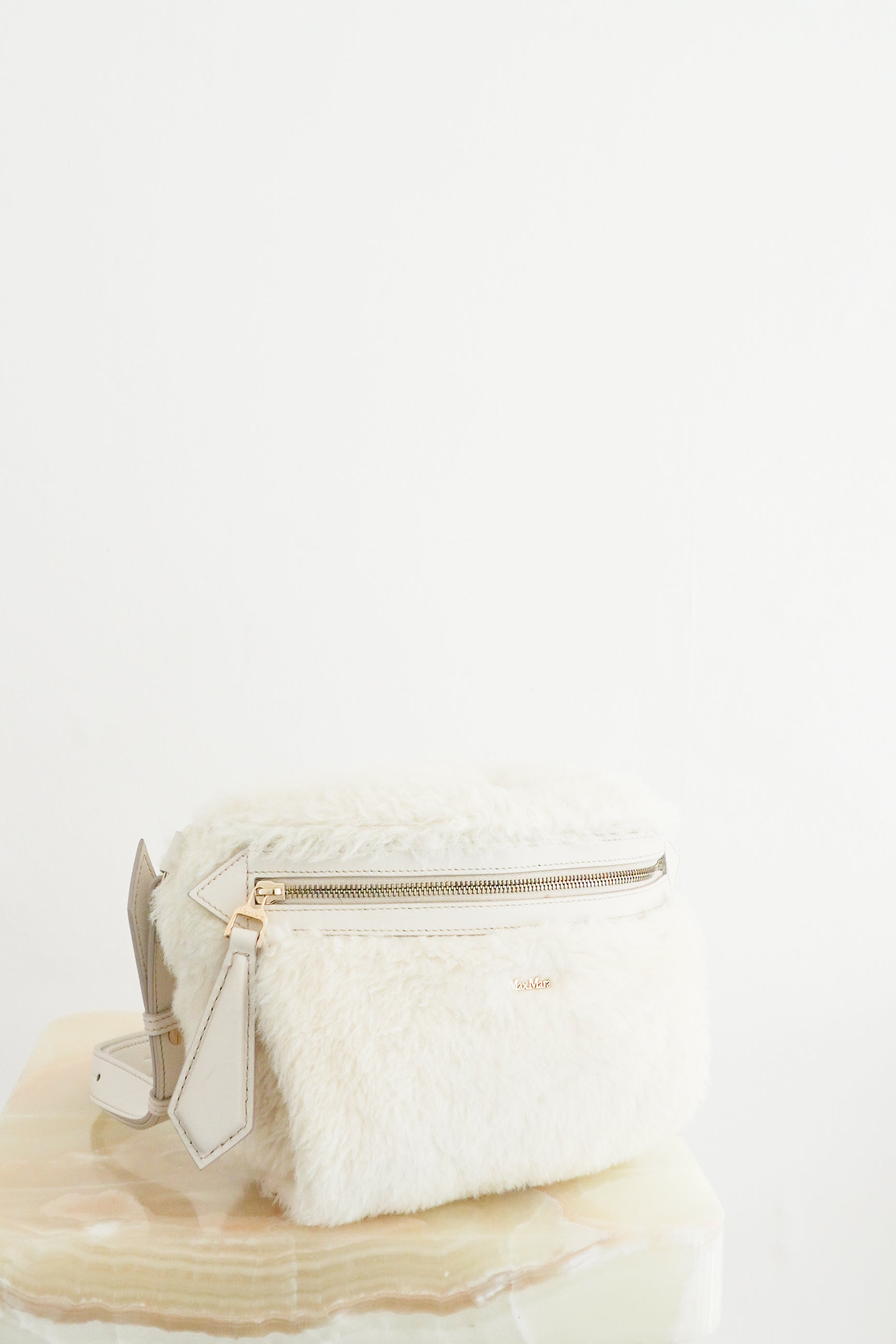 Front view photo of a MaxMara White Camelux Teddy Fur Shoulder Bag, featuring a plush textured exterior, gold-toned zipper hardware, and an attached leather strap.