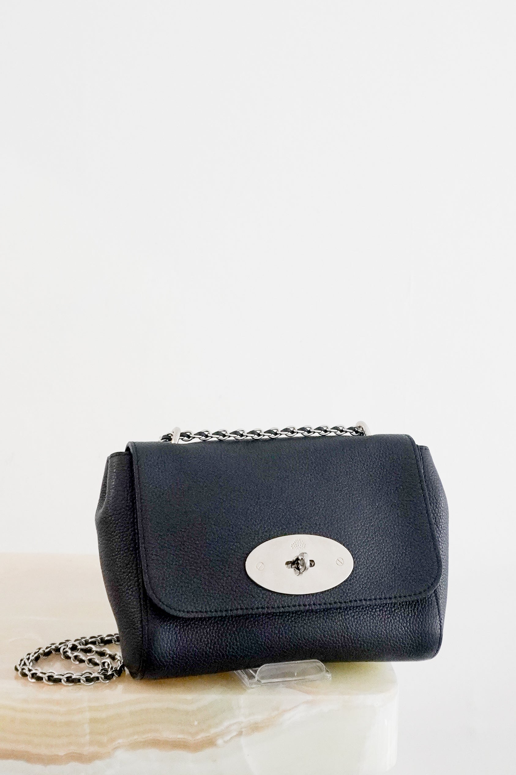 Front photo of a Mulberry Small Lily Crossbody Bag crafted from luxurious navy Classic Grain leather and finished with the brand's iconic Postman's Lock fastening in silver-tone hardware.