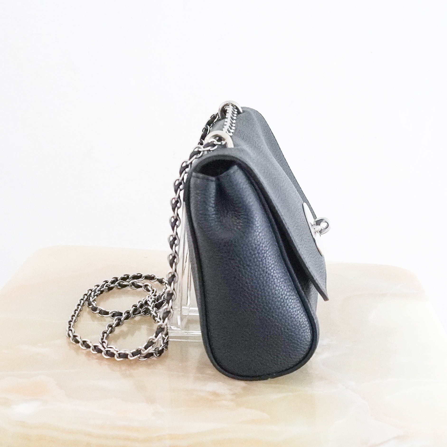 Side photo of a Mulberry Small Lily Crossbody Bag crafted from luxurious navy Classic Grain leather and finished with the brand's iconic Postman's Lock fastening in silver-tone hardware.