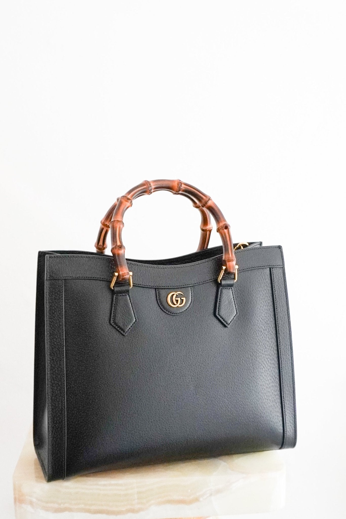 Front view of a Gucci Medium Diana Tote Bag in black leather with iconic bamboo top handles.