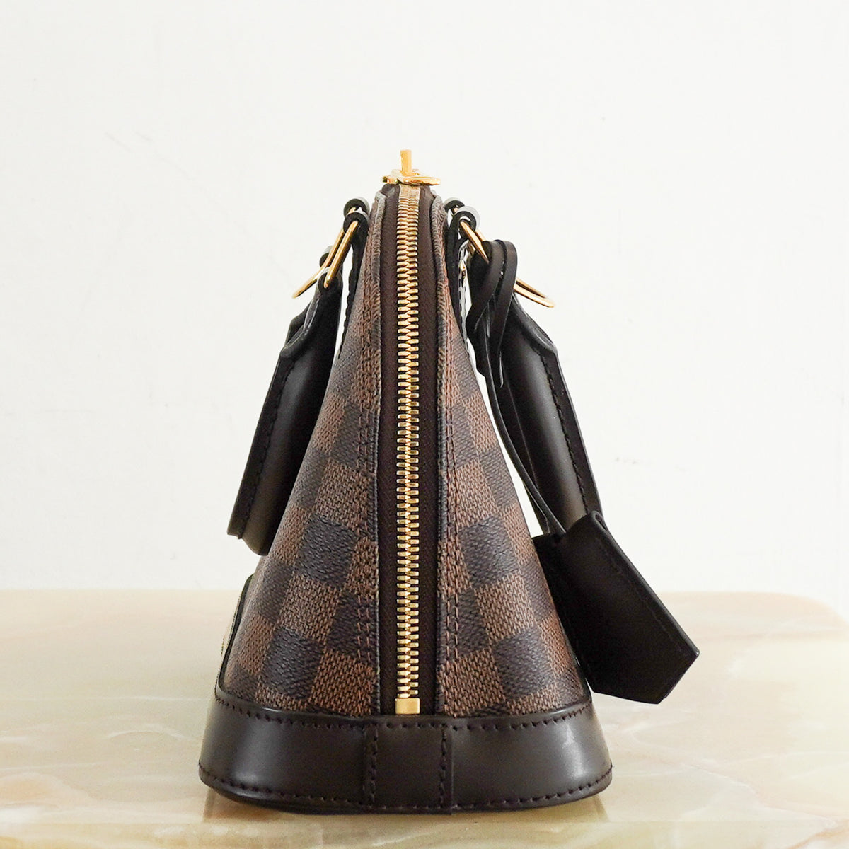 Side: Louis Vuitton Alma BB Bag in Damier Ebene Canvas