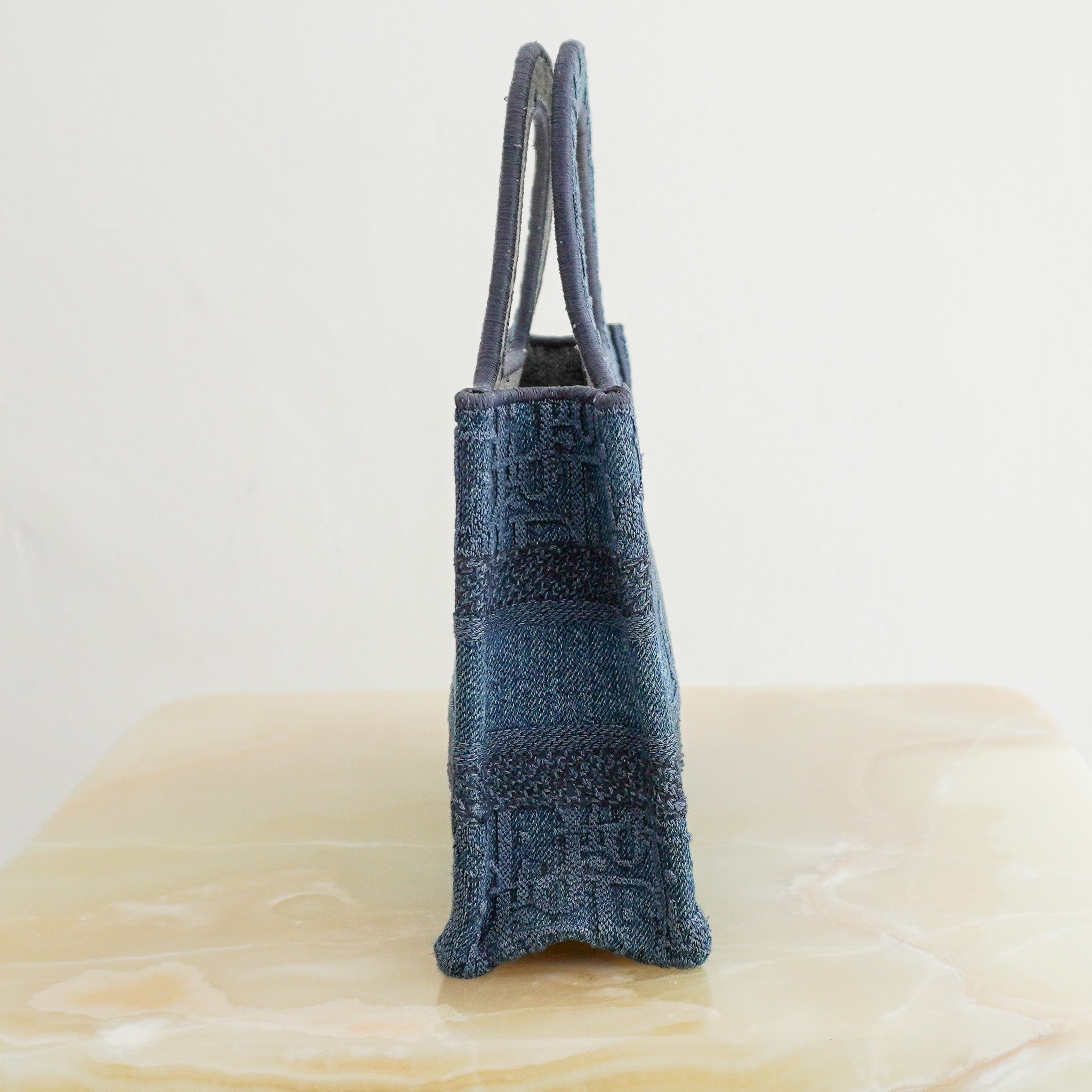 Side image of the Dior Oblique Embroidered Denim Mini Book Bag