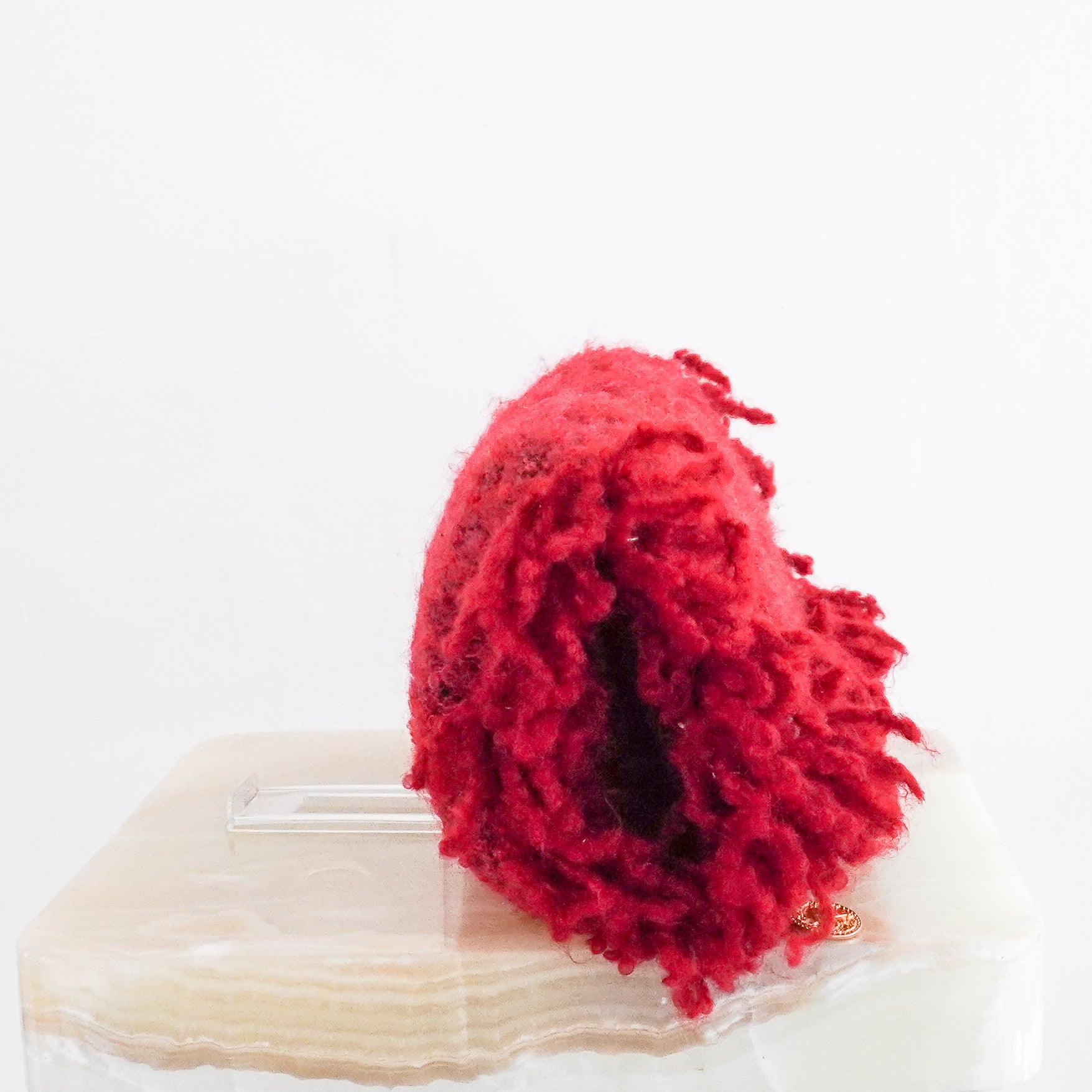 Side profile of the Chanel red tweed clutch highlighting the thick fringe edges and textured fabric.