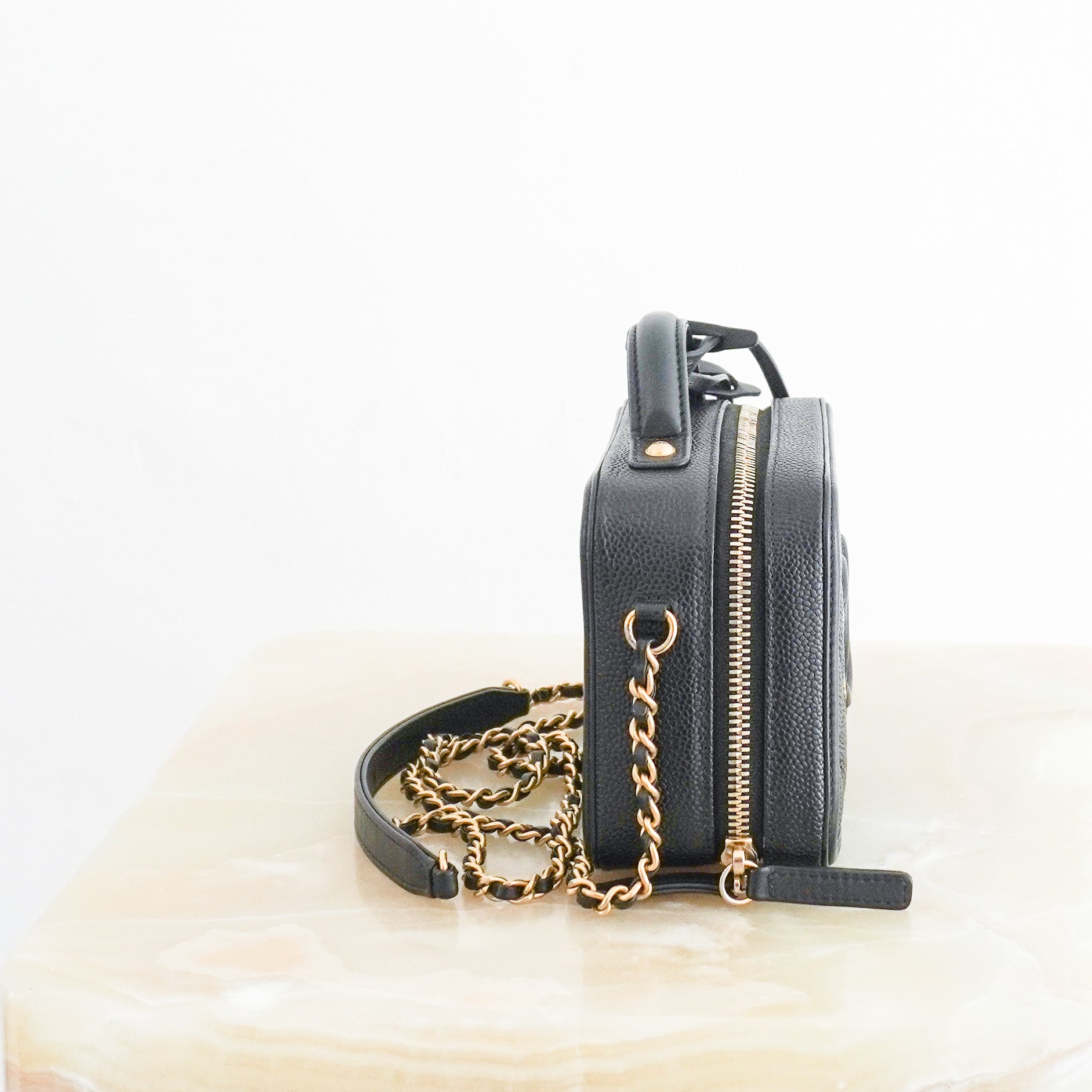 Side photo of a Chanel Vanity Case Crossbody Bag, crafted from luxurious black quilted caviar leather and finished with elegant champagne gold-tone hardware. 