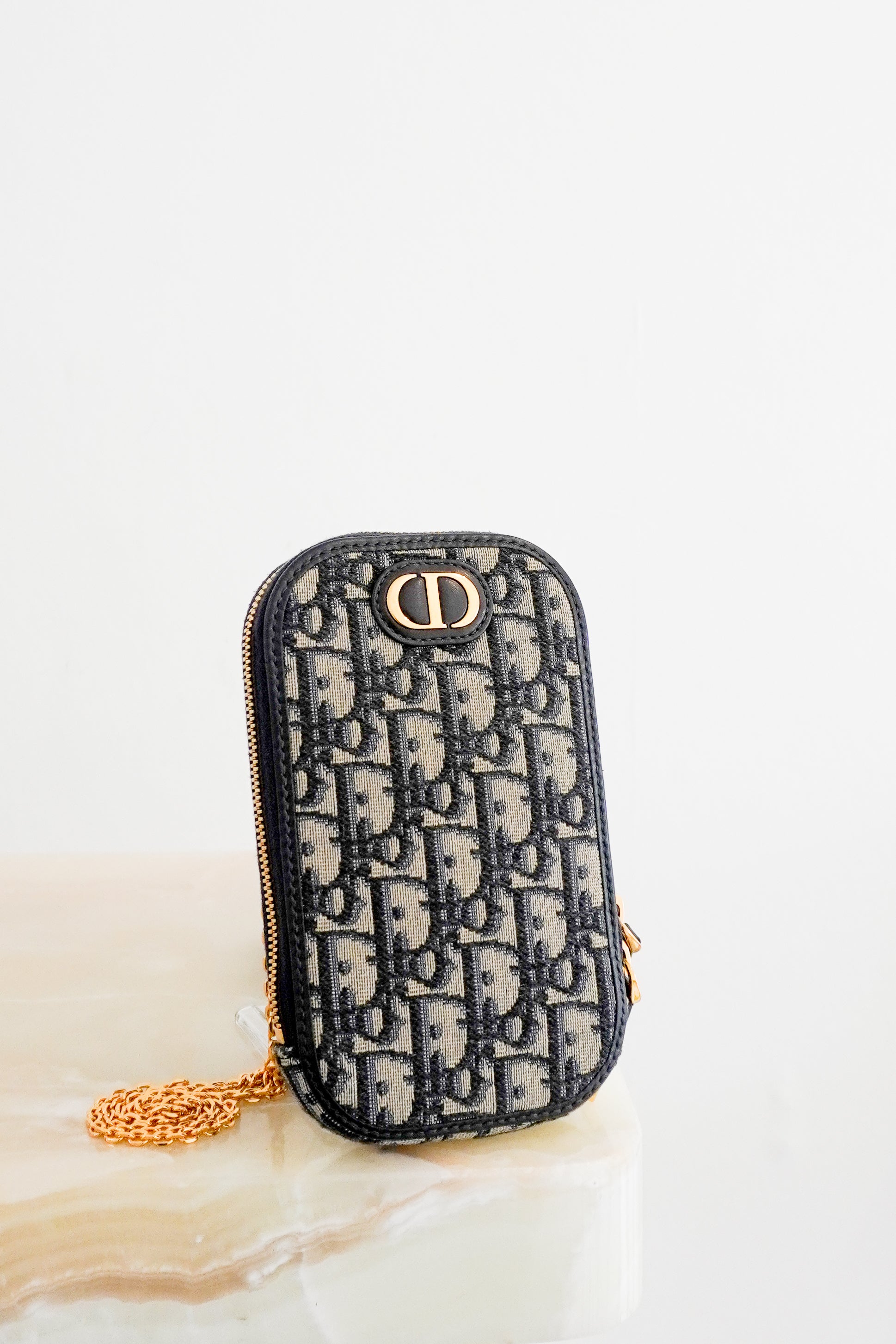 Front photo of a Dior 30 Montaigne Tech Holder is crafted from the House's iconic blue Dior Oblique jacquard canvas and finished with elegant gold-tone hardware.