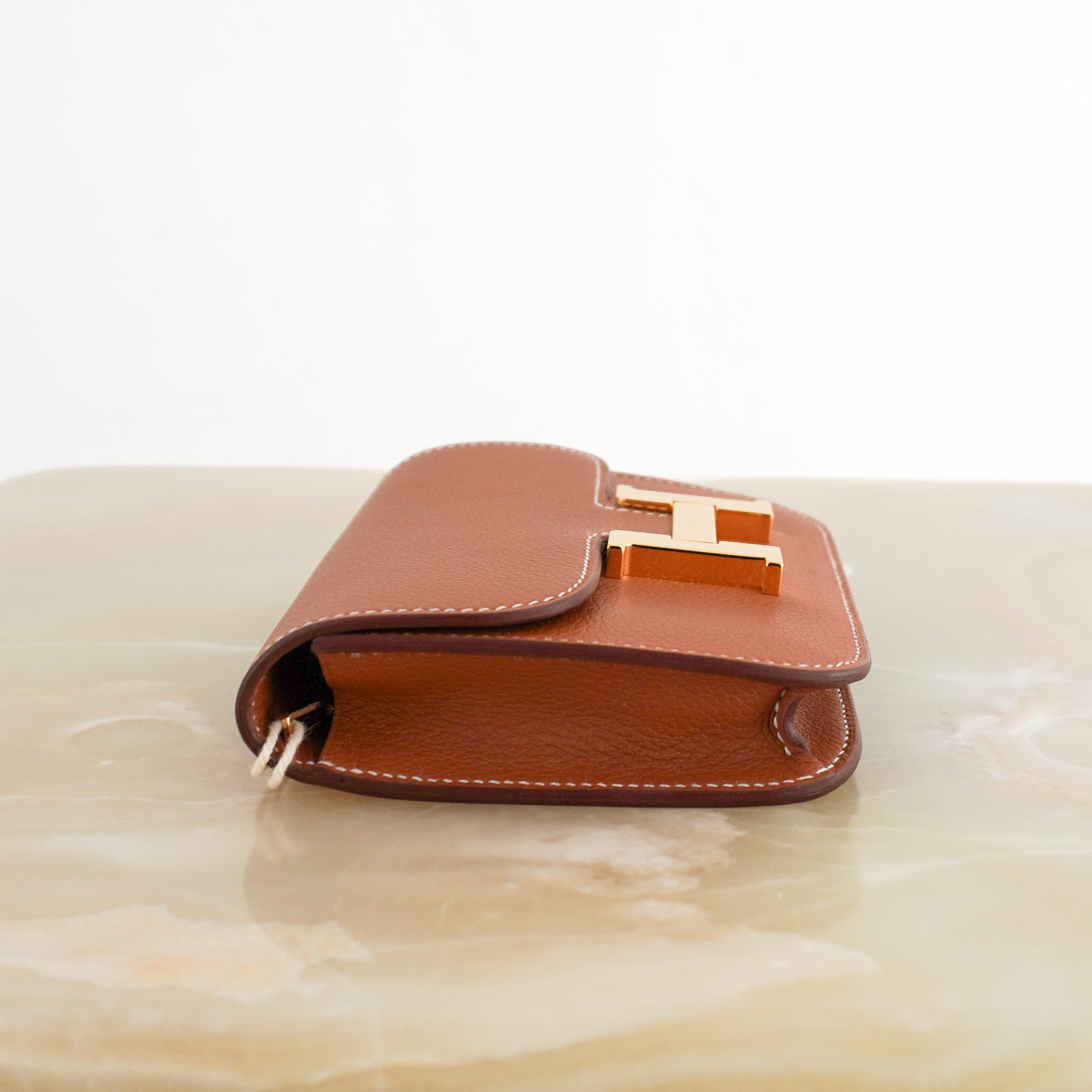 Hermès Constance Slim Wallet with Crossbody Strap in Gold side photo chelsea london