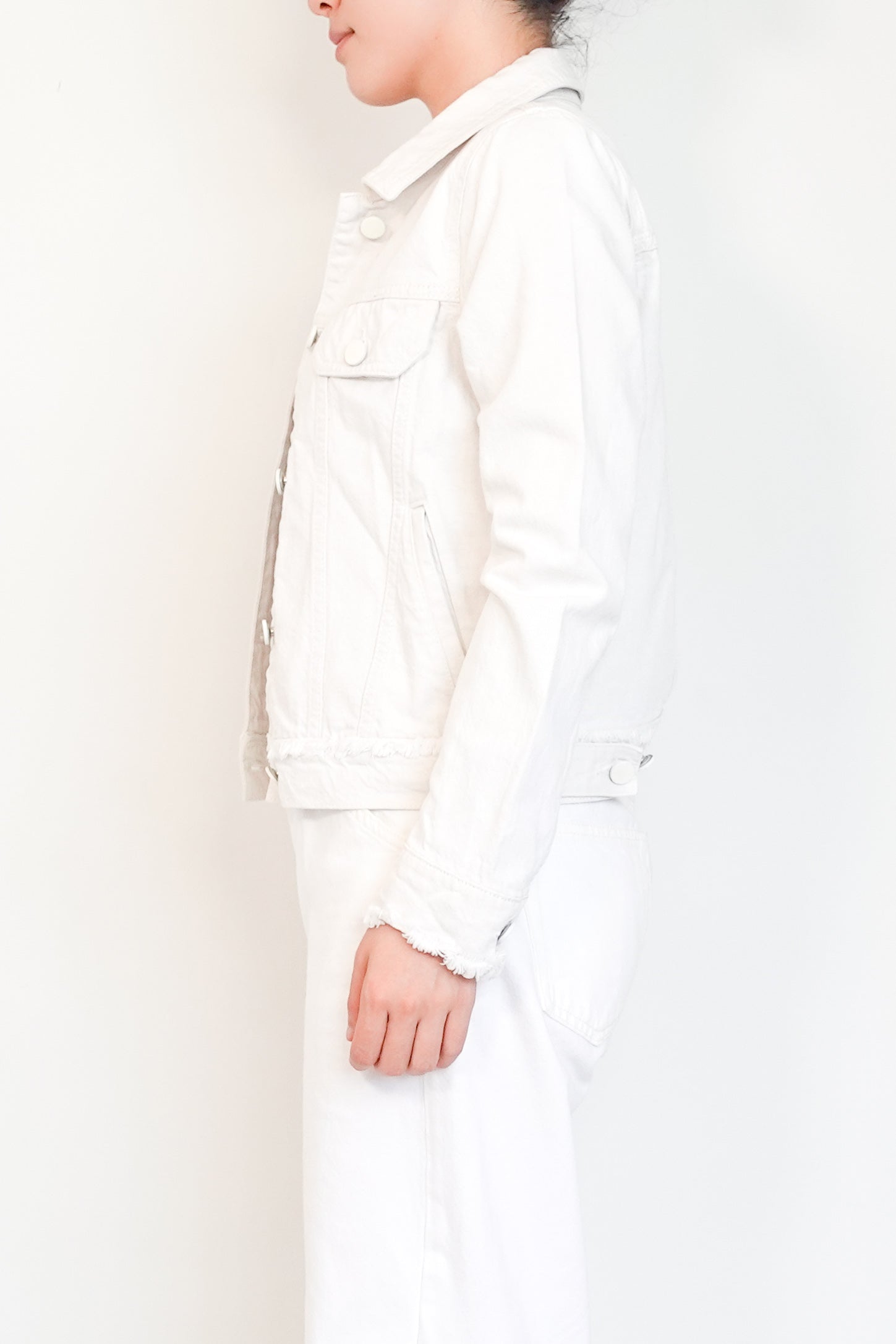 Person wearing a white coat against a plain background