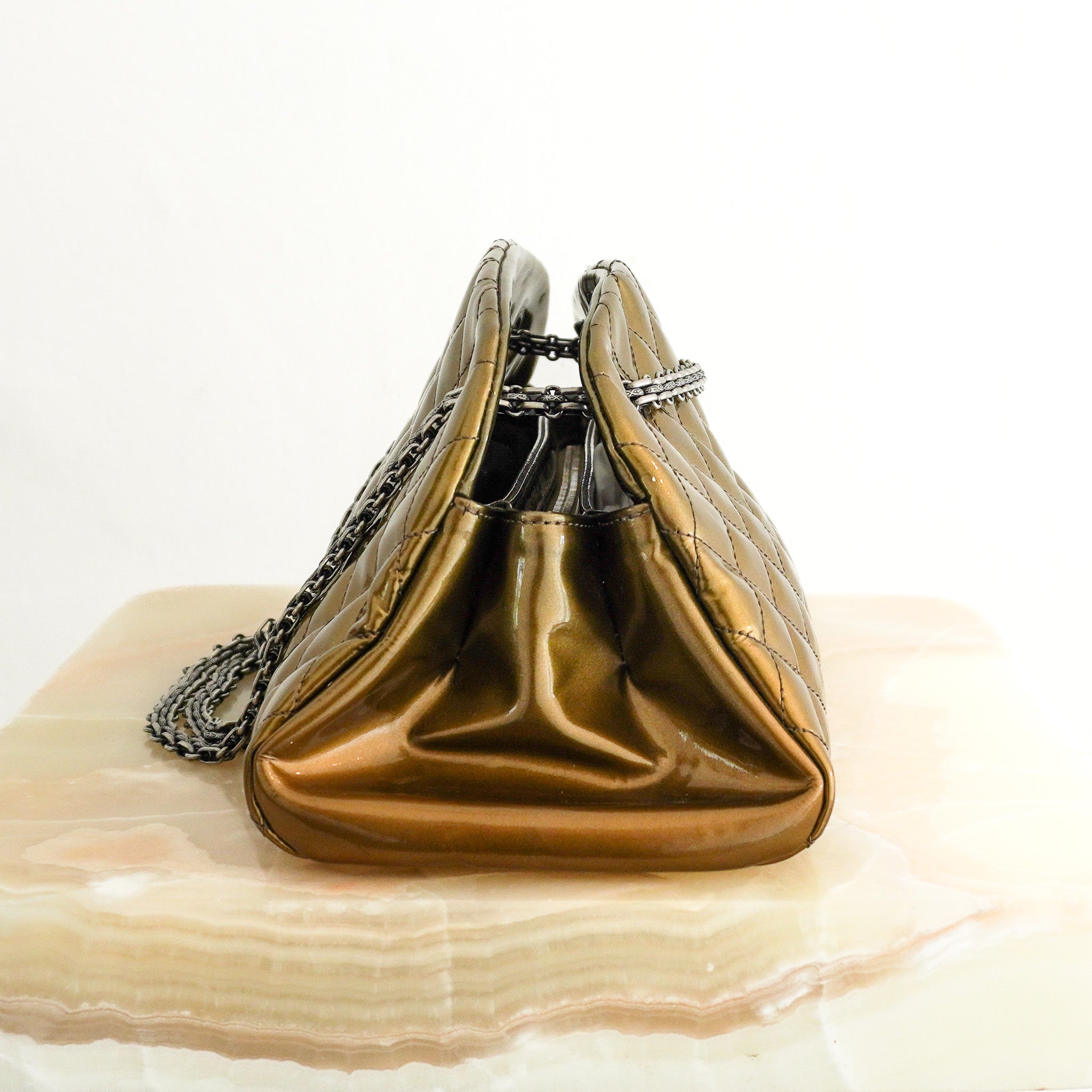 Side image of the Chanel Just Mademoiselle Patent Quilted Bag in Metallic Olive Green