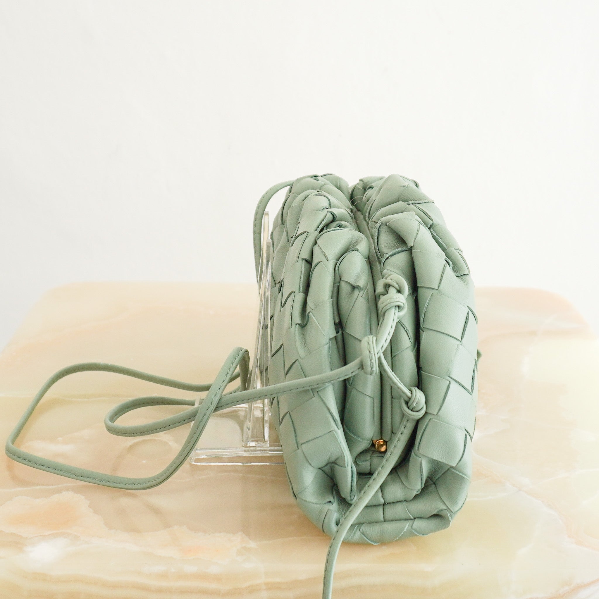 Side image of the Bottega Veneta Mini Intrecciato Pouch Crossbody Bag in Seafoam Green Leather 