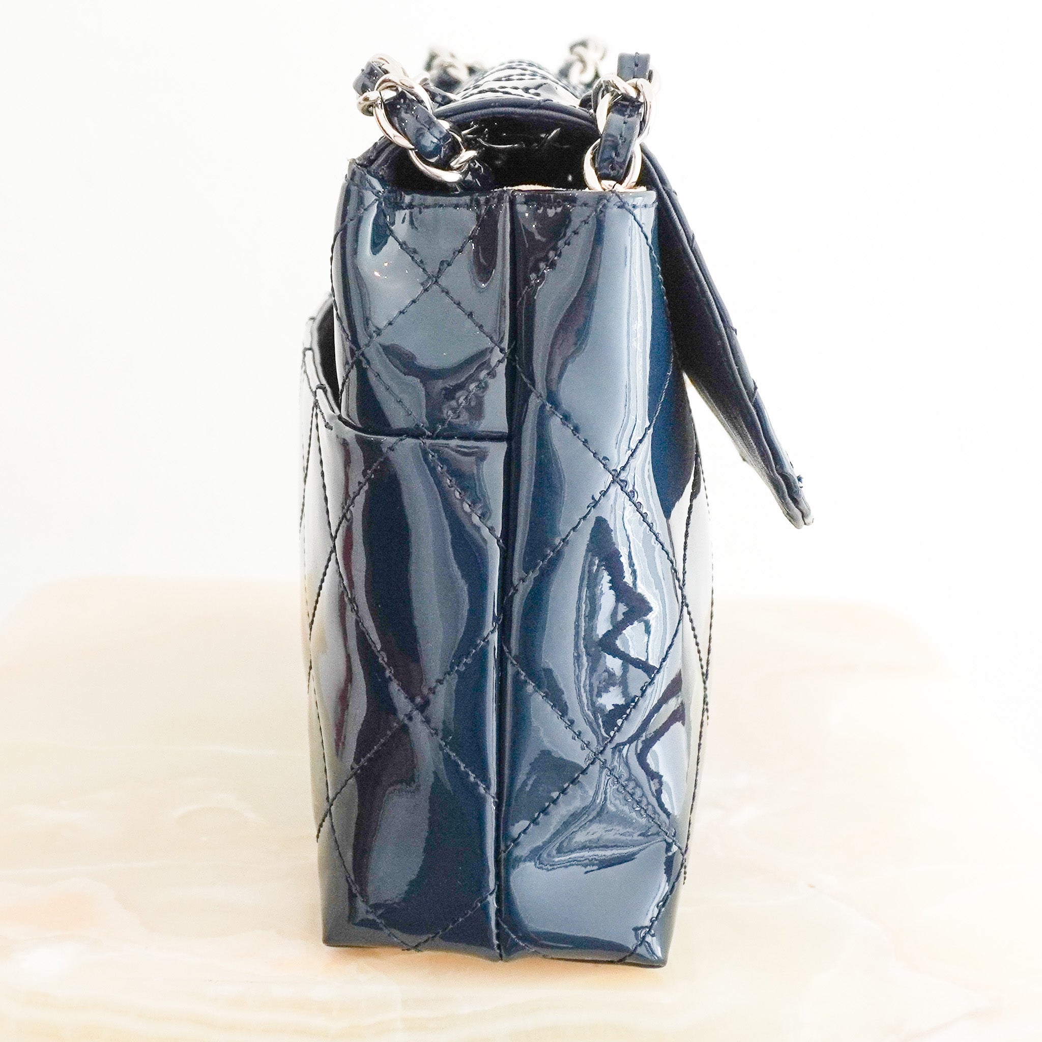Side photo of the Chanel Jumbo Patent Leather Flap Bag in Navy