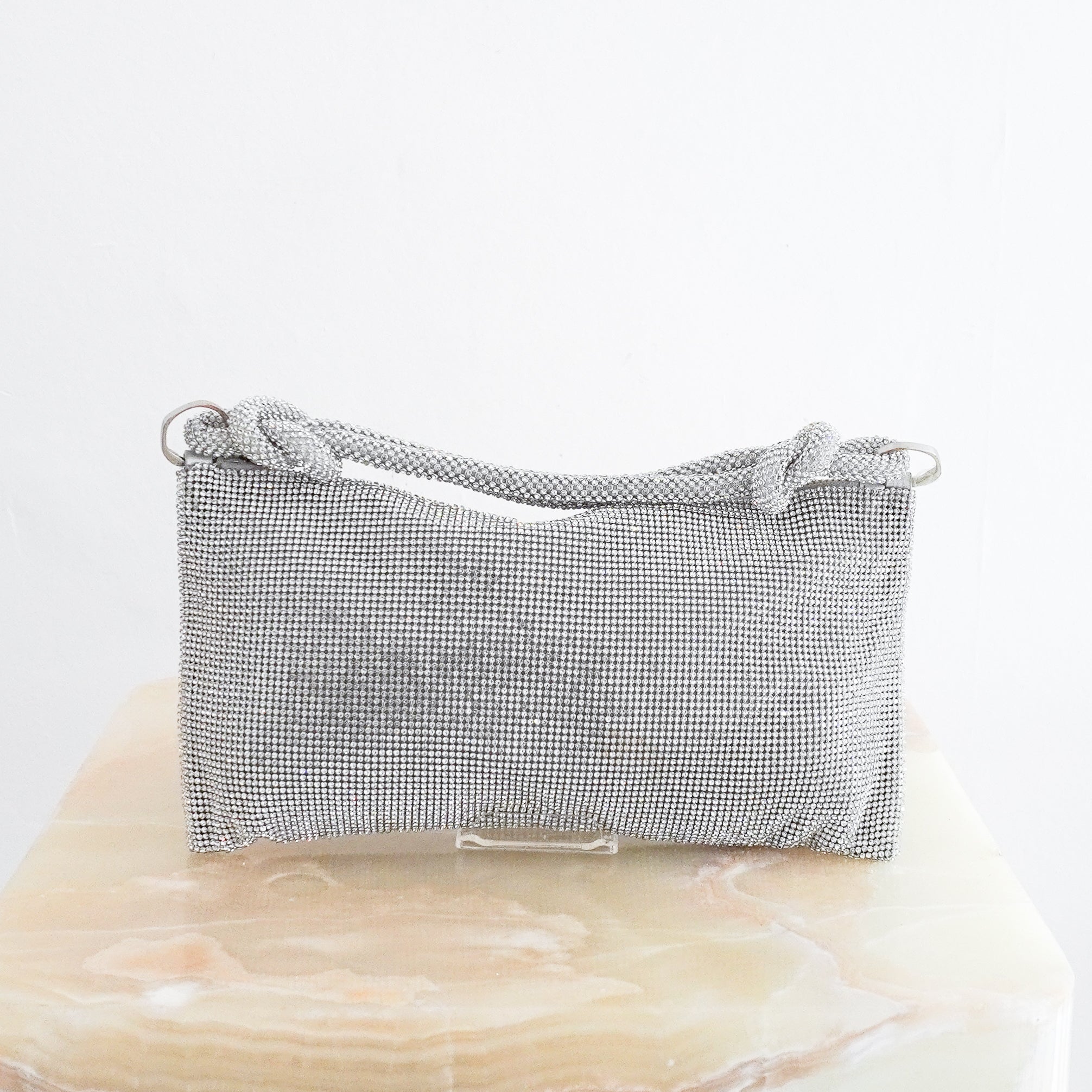 Silver Cult Gaia crystal embellished shoulder bag featuring an all-over rhinestone mesh exterior, knotted crystal shoulder strap, silver-tone hardware and zip-top closure.